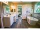 Elegant bathroom with a soaking tub, double vanity, and a seamless glass shower at 9995 Dolphin Gull Cir, Thonotosassa, FL 33592