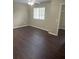 This bedroom features wood floors, a ceiling fan and a view of the exterior through a window at 17530 Hugh Ln, Land O Lakes, FL 34638