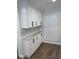 A spacious butler's pantry with granite countertops, white cabinets, and subway tile backsplash at 4780 Brittany S Dr # 111, St Petersburg, FL 33715
