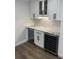 A butler's pantry features white cabinets, granite countertops, a wine fridge, and subway tile backsplash at 4780 Brittany S Dr # 111, St Petersburg, FL 33715