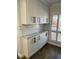 A spacious butler's pantry with granite countertops, white cabinets, and subway tile backsplash at 4780 Brittany S Dr # 111, St Petersburg, FL 33715