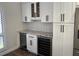 A butler's pantry features white cabinets, granite countertops, a wine fridge, and subway tile backsplash at 4780 Brittany S Dr # 111, St Petersburg, FL 33715
