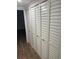 Hallway with wood floors and closets featuring louvered doors and matte black hardware at 4780 Brittany S Dr # 111, St Petersburg, FL 33715
