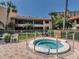 Outdoor hot tub surrounded by seating, landscaping, and condominium buildings at 4780 Brittany S Dr # 111, St Petersburg, FL 33715