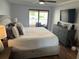 Bright main bedroom featuring a ceiling fan, a balcony, and a gray dresser with decor accents at 4780 Brittany S Dr # 111, St Petersburg, FL 33715