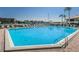 Beautiful community pool on a sunny day with lounge chairs, palm trees, and boat docks available at 4780 Brittany S Dr # 111, St Petersburg, FL 33715