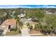 An aerial view of a yellow home featuring palm trees, mature landscaping, and a two-car garage at 7622 Hampshire Garden Pl, Apollo Beach, FL 33572