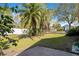 Lush backyard with a green lawn, mature trees, and a white privacy fence, creating a serene oasis at 7622 Hampshire Garden Pl, Apollo Beach, FL 33572
