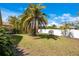 Spacious, tree-filled back yard with a white fence creating a beautiful outdoor living space at 7622 Hampshire Garden Pl, Apollo Beach, FL 33572