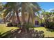 Backyard featuring a patio, lawn, and tropical palm trees at 7622 Hampshire Garden Pl, Apollo Beach, FL 33572