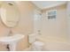Well-lit bathroom with a tub and shower combination and a pedestal sink at 7622 Hampshire Garden Pl, Apollo Beach, FL 33572