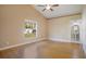 Comfortable bedroom with hardwood floors, neutral walls, and backyard view at 7622 Hampshire Garden Pl, Apollo Beach, FL 33572