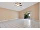 Bright room featuring tile floors, tan walls, ceiling fan, and sliding glass doors to the outside at 7622 Hampshire Garden Pl, Apollo Beach, FL 33572