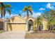 Charming single-story home with a two-car garage and well-maintained landscaping featuring tropical palm trees at 7622 Hampshire Garden Pl, Apollo Beach, FL 33572