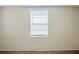 Bright bedroom featuring wood-look flooring, a window with blinds, and neutral-painted walls at 1542 39 S St, St Petersburg, FL 33711