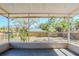 Screened in porch overlooking backyard with mature trees and fence at 1542 39 S St, St Petersburg, FL 33711