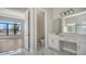 Elegant bathroom featuring marble flooring, dual sinks, vanity, and an open view of the bedroom at 4541 Mondrian Ct, Sarasota, FL 34240