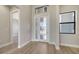 Inviting entryway with wood-look flooring, glass-paneled front door, and modern black-framed windows at 4541 Mondrian Ct, Sarasota, FL 34240