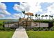 Community playground with slides and play equipment, surrounded by a black metal fence at 4541 Mondrian Ct, Sarasota, FL 34240