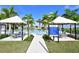 Beautiful community pool area with covered seating, lush landscaping, and clear blue water at 4541 Mondrian Ct, Sarasota, FL 34240