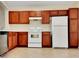 Well-equipped kitchen featuring wooden cabinets, white appliances, and ample counter space for culinary enthusiasts at 523 Glenn Cross Dr, Ruskin, FL 33570