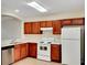 Functional kitchen featuring wooden cabinets, white appliances, and ample counter space, ready for meal preparation at 523 Glenn Cross Dr, Ruskin, FL 33570