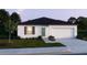 Charming single story home with lush lawn, a gray roof, and an attached two-car garage at 1317 Arrow St, Port Charlotte, FL 33952