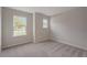 Light-filled bedroom with carpet, trim, and two windows providing natural light at 22500 Provance Ave, Port Charlotte, FL 33954