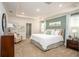 Spacious primary bedroom with tray ceiling, ensuite bathroom, and neutral carpet at 22500 Provance Ave, Port Charlotte, FL 33954