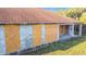 Detailed view of the rear of a single-story home, featuring boarded-up windows and weathered concrete at 6098 San Salvador Rd, North Port, FL 34291