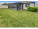 Large backyard with a screened in patio and well-maintained grass at 9793 Rally Spring Loop, Wesley Chapel, FL 33545