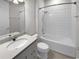 Bathroom with white tiled shower and gray vanity at 9793 Rally Spring Loop, Wesley Chapel, FL 33545