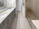 Modern bathroom with a double sink vanity, a tiled shower, and neutral finishes at 9793 Rally Spring Loop, Wesley Chapel, FL 33545