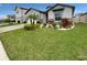 Charming one-story home featuring a well-manicured lawn, lush landscaping, and a welcoming facade at 9793 Rally Spring Loop, Wesley Chapel, FL 33545