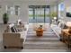 Bright living room with neutral walls, minimalist decor, and sliding glass doors to the patio at 9793 Rally Spring Loop, Wesley Chapel, FL 33545