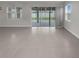 Open floor plan living room features tile flooring and sliding glass doors to the backyard at 9793 Rally Spring Loop, Wesley Chapel, FL 33545