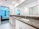 Bathroom featuring a dual sink vanity with granite countertops and a large mirror at 6471 Beverly Hills Dr, Zephyrhills, FL 33541