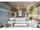 Inviting front porch with white stairs, potted plants, and covered seating at 7961 50Th N Ave, St Petersburg, FL 33709