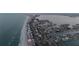 Aerial view of beachfront road alongside homes and ocean waves featuring city in the background at 2200 Bay Blvd # B, Indian Rocks Beach, FL 33785