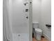 Modern bathroom featuring a stylish shower with white tiles and a toilet with sleek black fixtures at 2200 Bay Blvd # B, Indian Rocks Beach, FL 33785