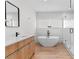 Modern bathroom with wood-look floors, a soaking tub, and a glass-enclosed shower at 2200 Bay Blvd # B, Indian Rocks Beach, FL 33785