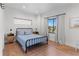 Bright bedroom features a bed, bedside tables, and a window with curtains at 2200 Bay Blvd # B, Indian Rocks Beach, FL 33785