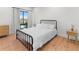 Light-filled bedroom featuring a full-sized bed, wood floors, and a large window at 2200 Bay Blvd # B, Indian Rocks Beach, FL 33785
