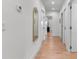 Bright hallway with hardwood floors, white walls, recessed lighting, and a decorative gold mirror at 2200 Bay Blvd # B, Indian Rocks Beach, FL 33785