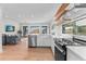 Open-concept kitchen featuring stainless steel appliances, floating shelves and view to living room at 2200 Bay Blvd # B, Indian Rocks Beach, FL 33785