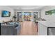 Bright, open living room with hardwood floors, large sliding doors to balcony, dining area, and modern decor at 2200 Bay Blvd # B, Indian Rocks Beach, FL 33785