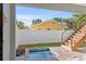 Cozy in-ground pool with brick surround and wooden stairs to second story deck within a fenced backyard at 2200 Bay Blvd # B, Indian Rocks Beach, FL 33785
