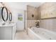 Relaxing bathroom with a jacuzzi tub, double sinks, and a separate tiled shower at 5802 Hatteras Palm Way, Tampa, FL 33615