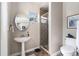 Charming bathroom featuring pedestal sink, walk-in shower with tile surround, and neutral color palette at 5802 Hatteras Palm Way, Tampa, FL 33615