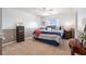 Cozy bedroom with a patterned comforter set, carpeted floors, and a bright window at 5802 Hatteras Palm Way, Tampa, FL 33615